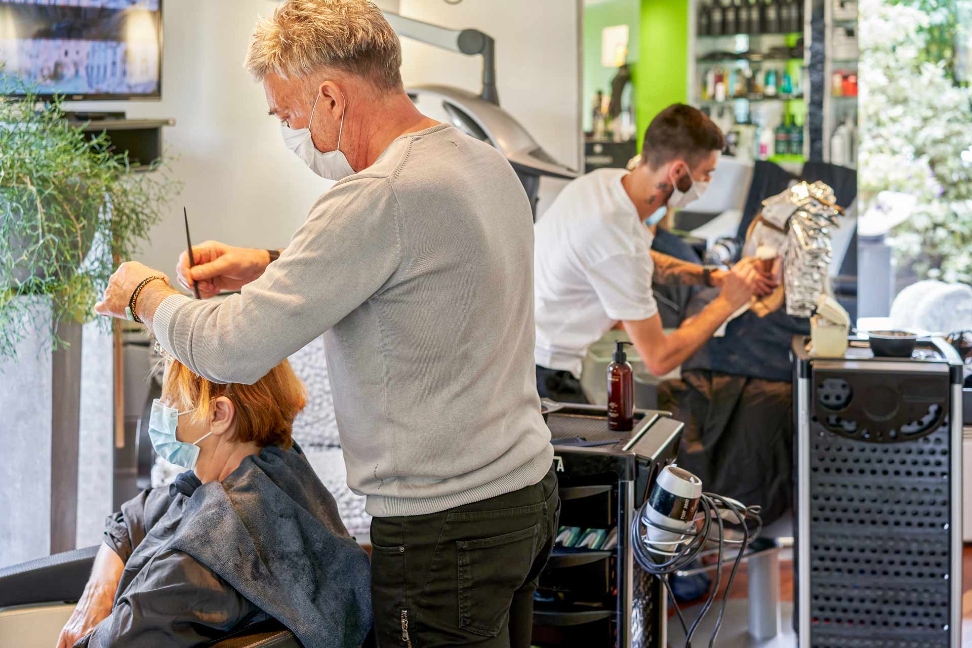 Dans le salon de Jacky Coiff, un coiffeur qui coupe les cheveux d'une femme